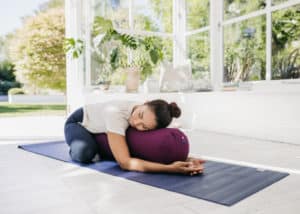 Posture de l'enfant avec bolster pour les règles douloureuses